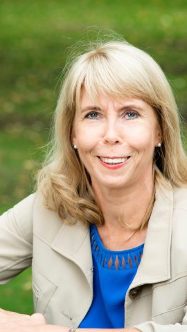 Blond naeratav naine heleda jakiga